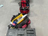 une boîte à outils et des outils posés par terre dans un garage