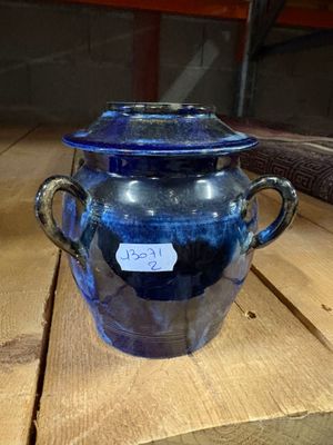 un bocal en verre bleu muni d'une étiquette, posé sur une table en bois