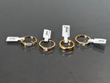 three gold rings with tags on them sitting on a table