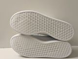 the soles of a pair of white tennis shoes are stacked on top of each other