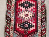 a red and blue rug on a white floor
