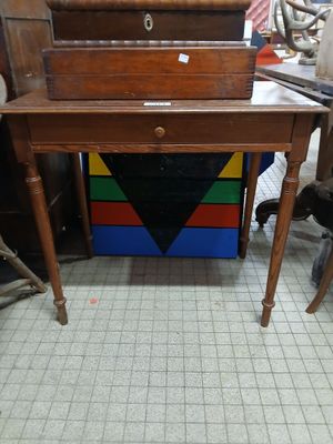 a small wooden desk with a drawer on top of it