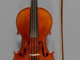 a violin with a bow and a bow rest on the wall