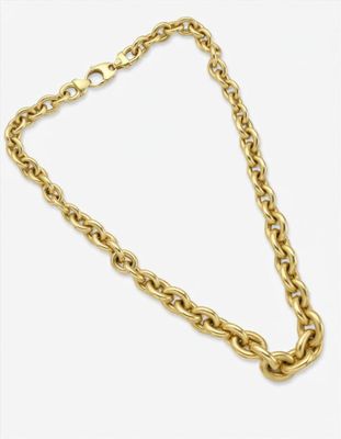 gros plan d'un collier en chaîne en or sur fond blanc