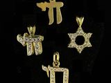 a set of four gold plated charms with hebrew symbols