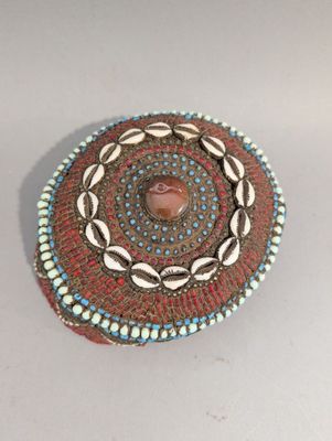 une photo d'une broche ornée de coquillages et de perles
