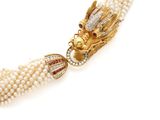 a close up of a necklace with pearls and a dragon head