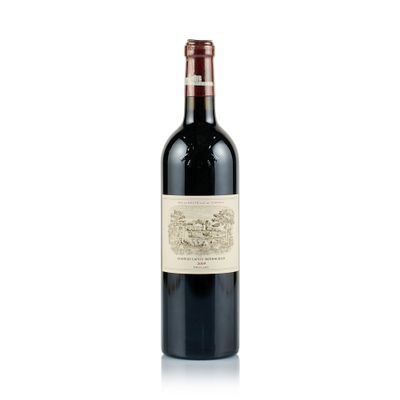 the bottle of red wine is sitting on a white surface