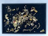 a black tray with a bunch of jewelry in it
