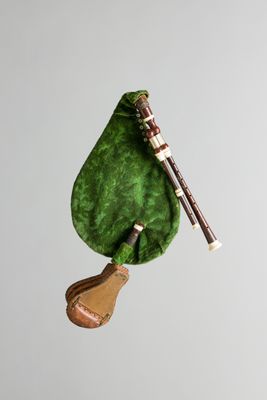 un sac vert auquel est accroché un instrument de musique