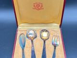four spoons and a fork in a red case