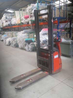 a fork lift truck parked in a warehouse filled with bags