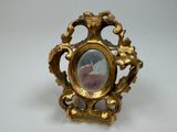 a gold frame with a picture in it on a white surface