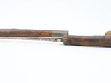 a close up of a knife with a wooden handle on a white surface