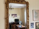 a mirror on the wall above a chair in a living room