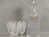 des bouteilles et des verres posés sur une table, sur fond gris