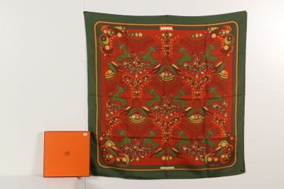 une écharpe rouge et verte accrochée au mur à côté d'une boîte orange