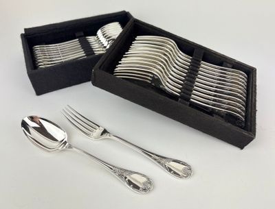 silverware in a black box on a white surface with a fork and spoon