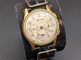 une photo d'une montre-bracelet en or avec un bracelet en cuir noir