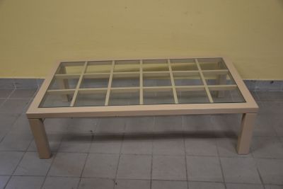 Table basse en bois laqué crème, le plateau en verre portant…