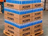 Des cartons d'eau sont empilés sur une palette dans un entrepôt