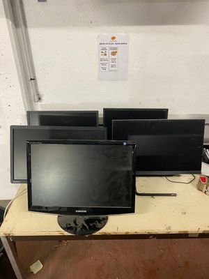 trois ordinateurs portables posés sur une table dans une pièce