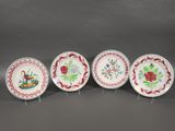 four plates with flowers and birds on them on a stand