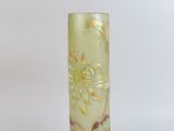 a glass vase with a flower on it on a table