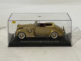 a gold model of a car in a clear case