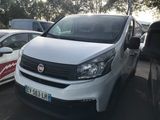 une camionnette blanche garée dans un parking avec d'autres voitures