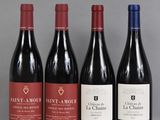 quatre bouteilles de vin sont alignées sur une table