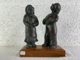 deux figurines posées sur un socle en bois