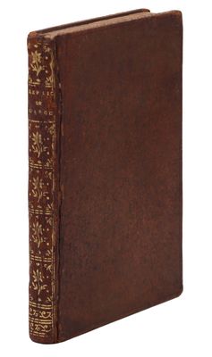 an old book with a brown cover sitting on top of a white surface