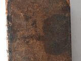 an old book sitting on top of a table next to a white wall