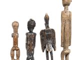 three wooden figurines sitting next to each other on a white surface