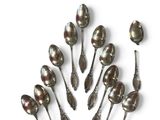 six spoons are arranged in a circle on a white surface