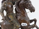 statue of a man on a horse with a sword on a rock