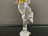 un oiseau en verre posé sur une table en verre