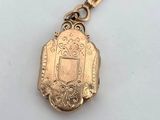 a close up of a gold key chain with a locke on it