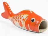 an orange and white fish figurine on a white surface