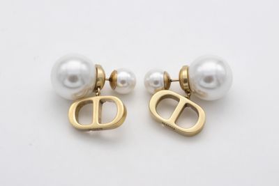 une paire de boucles d'oreilles en perles et en or ornées d'une lettre « d »