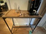 a small table with a coffee maker on top of it