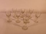 several empty wine glasses are lined up on a white table