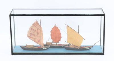 deux petits bateaux dans une vitrine posée sur une table