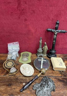 a wooden table with a cross, a book, a candle, and other items on it