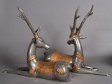 two metal deer statues laying on the ground