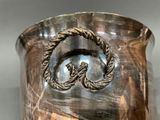 a large silver vase with a rope handle on it