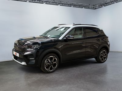 un SUV noir garé dans une grande pièce aux murs blancs
