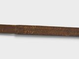 a long piece of wood with writing on it