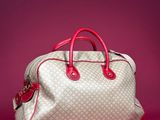 beige and red guccissi bag on a pink background
